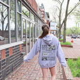 a woman walking down a sidewalk in front of a building