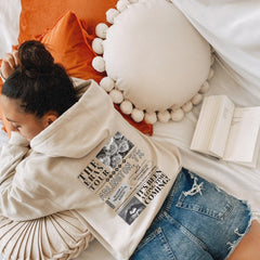 a woman laying on top of a bed next to a book