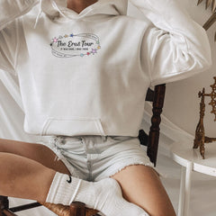 a woman sitting in a chair wearing a white hoodie