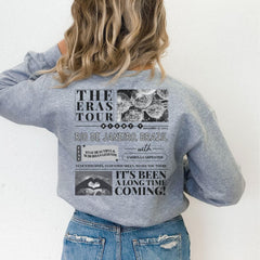 a woman wearing a gray sweatshirt with a tour poster on it