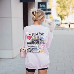 a woman walking down a street holding a small dog