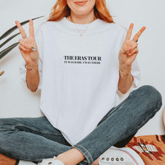 a woman sitting on the floor making a peace sign