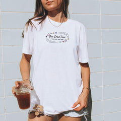 a woman holding a drink and wearing a white shirt