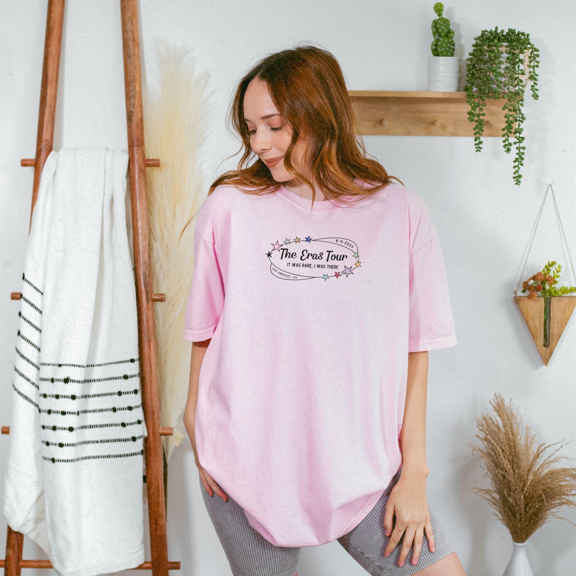 a woman standing in front of a wall wearing a pink shirt