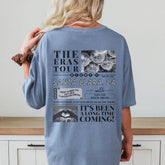 a woman standing in front of a counter wearing a blue tshirt