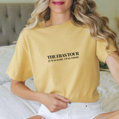 a woman sitting on a bed wearing a yellow shirt