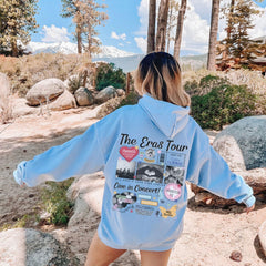 a woman in a blue hoodie is standing on a rock