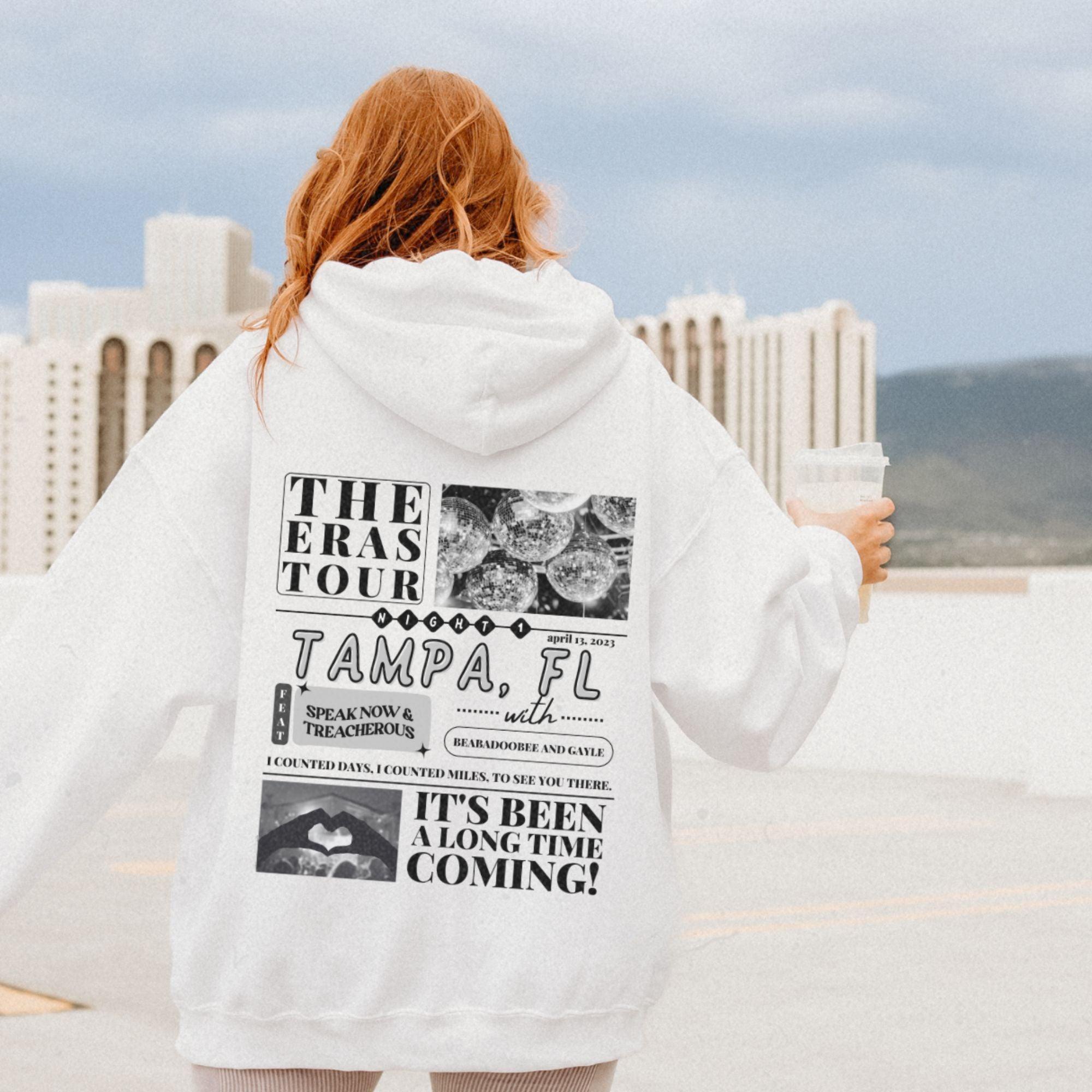 a woman in a white hoodie is holding a coffee cup
