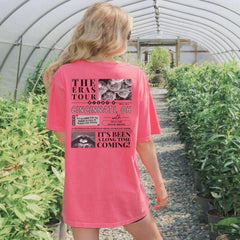 a woman in a pink shirt is walking through a greenhouse