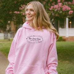 a woman in a pink hoodie is smiling