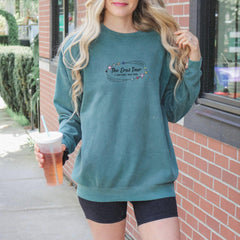 a woman standing outside of a building holding a drink