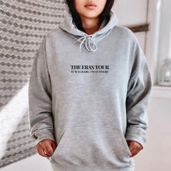 a woman in a grey hoodie is posing for a picture