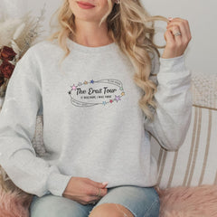 a woman sitting on a couch wearing a grey sweatshirt