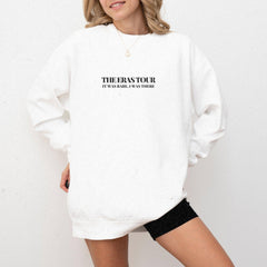 a woman wearing a white sweatshirt and black shorts