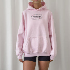 a woman wearing a pink hoodie with the words the great tour on it