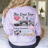 a woman sitting on top of a bed wearing a sweatshirt