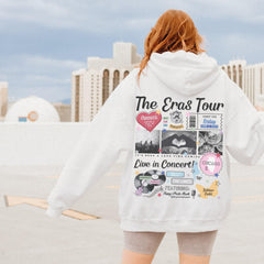a woman wearing a white hoodie with the words the eras tour written on it