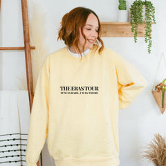 a woman wearing a yellow sweatshirt with the words the eastator printed on it