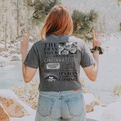 a woman standing in front of a river with her hands in the air