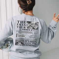 a woman wearing a sweatshirt with a newspaper print on it