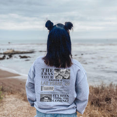 a person with long hair standing on a beach