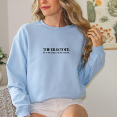 a woman wearing a blue sweatshirt and white shorts