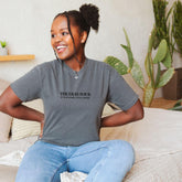 a woman sitting on a bed with her hands on her hips