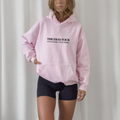 a woman wearing a pink sweatshirt and black shorts