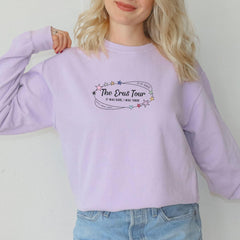 a woman wearing a purple sweatshirt with the words the east tour on it