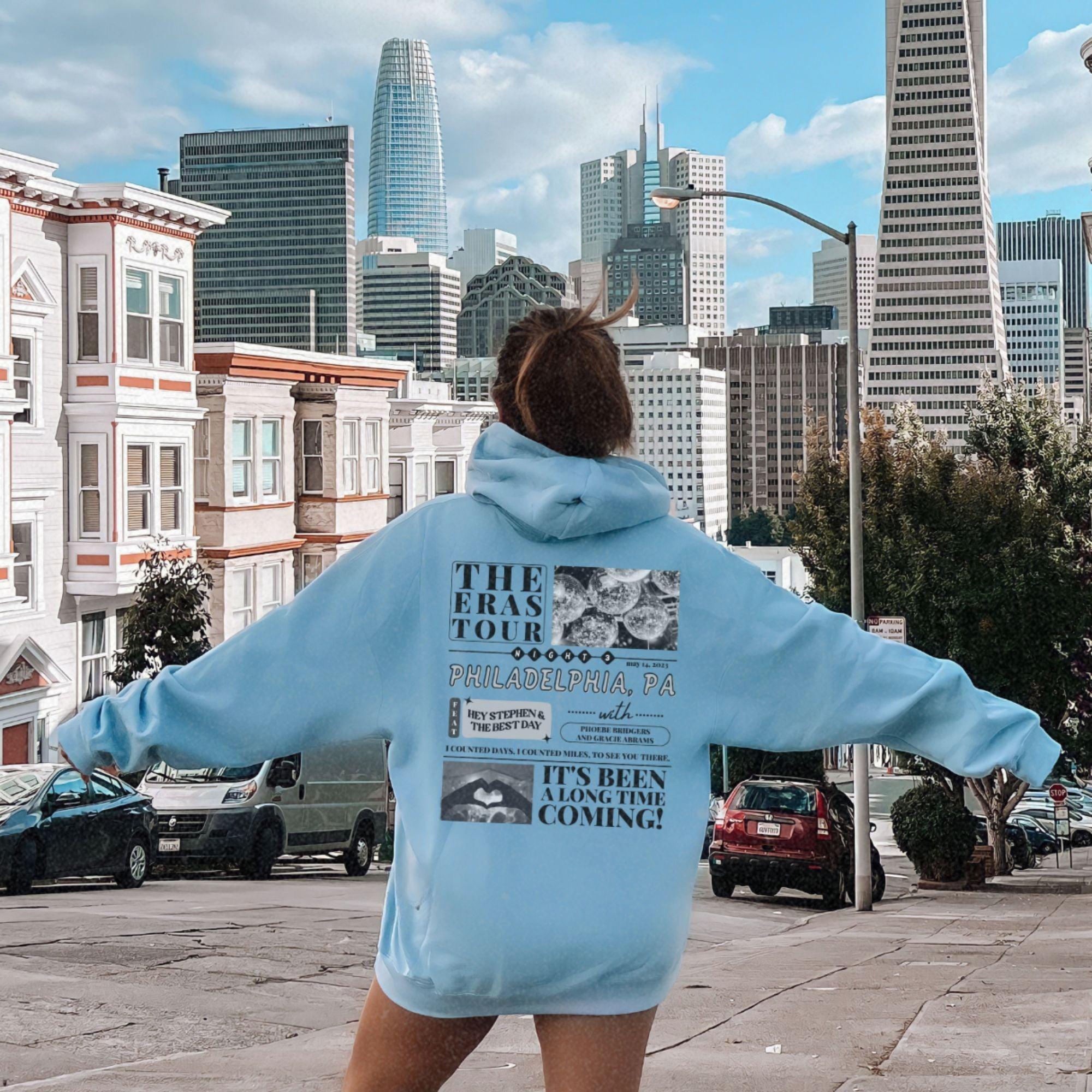 a woman in a blue hoodie is standing on a skateboard