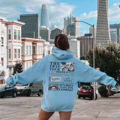 a woman in a blue hoodie is standing on a skateboard
