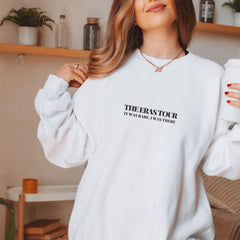 a woman in a white sweatshirt holding a coffee cup