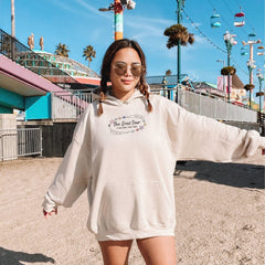 a woman in a white hoodie is standing on a skateboard