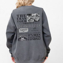a woman wearing a gray sweatshirt jacket with the words the fras tour on it