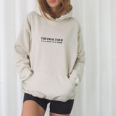a woman wearing a white hoodie with the words the rest for it on it