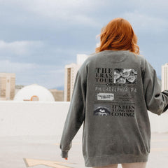 a woman with red hair wearing a gray sweatshirt