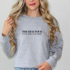 a woman wearing a grey sweatshirt with the words the overstour on it