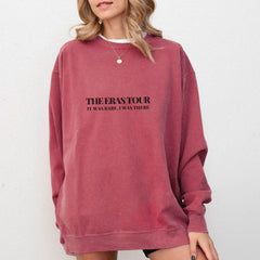 a woman wearing a red sweatshirt with the words the best tour on it
