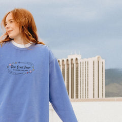 a woman in a blue sweatshirt with the words the great tour on it