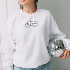 a woman in a white sweatshirt holding a disco ball