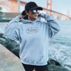 a woman in a blue hoodie is standing by the water