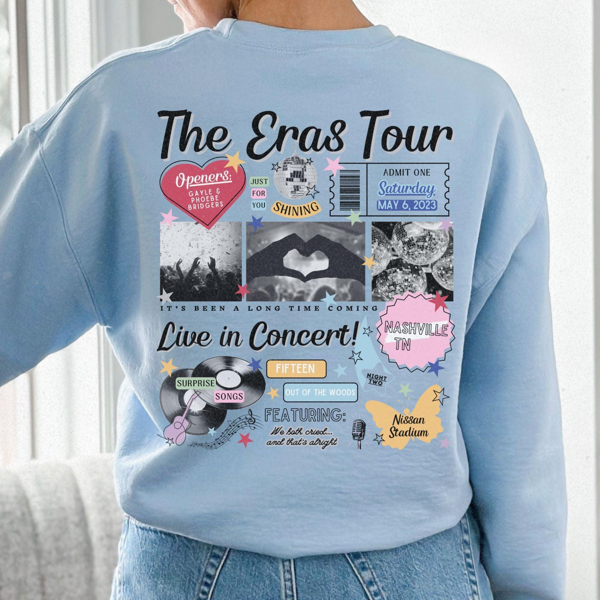 a woman wearing a blue sweatshirt with the words the eras tour on it