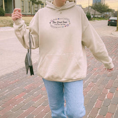 a woman in a hoodie is walking down the street