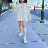 a woman walking down a sidewalk holding an umbrella