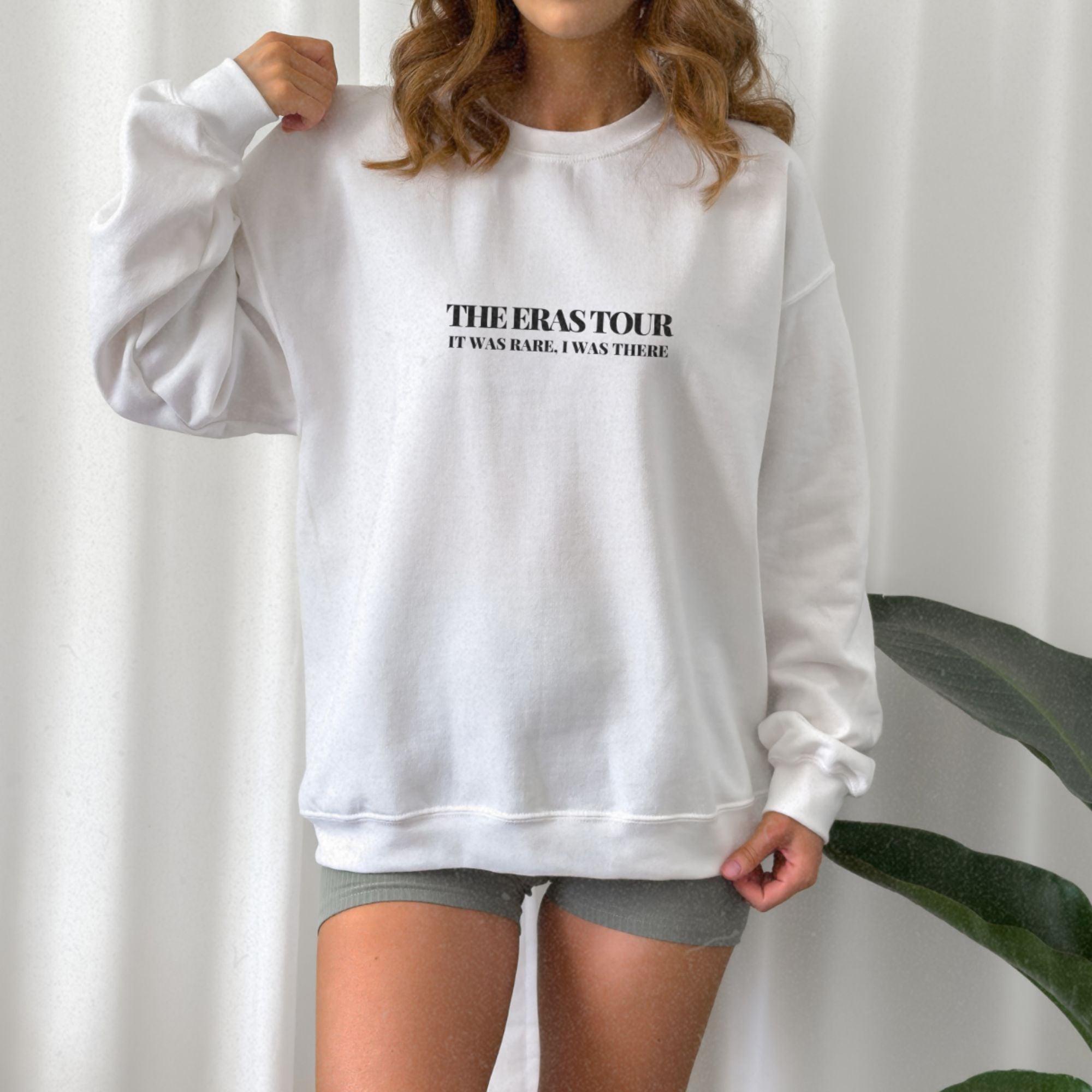a woman wearing a white sweatshirt and shorts