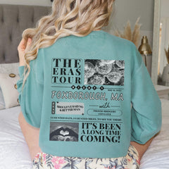 a woman sitting on top of a bed wearing a blue shirt