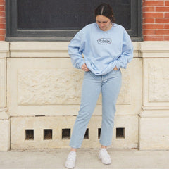 a woman leaning against a wall with her hands on her hips