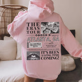a person wearing a pink hoodie with pictures on it