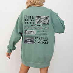 a woman wearing a green sweatshirt jacket with the words the eras tour on it