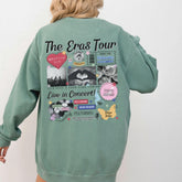 a woman wearing a green sweatshirt with the words the eras tour on it